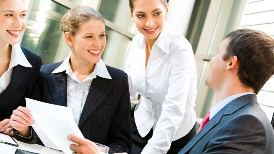 Image of three women looking at business man in a office